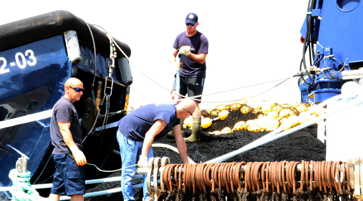 Tres mariners preparen un dels vaixells de la flota tonyinaire de l'Ametlla de Mar, abans de sortir de port. Anna Ferràs (ACN)