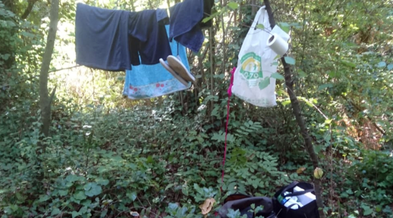 Pla detall de roba i deixalles d'un usuari incívic als gorgs de les Planes d'Hostoles (Garrotxa) en una imatge de l'agost del 2019. ACN