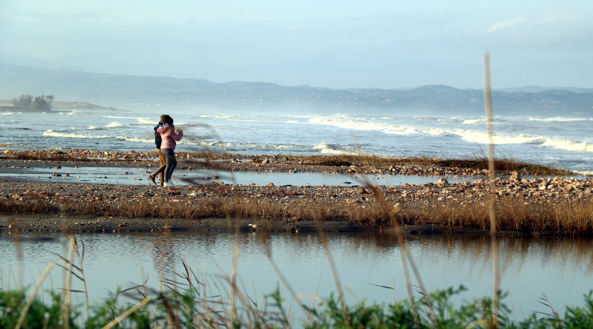 Una parella passejant al costat del mar que ha arrasat la zona de dunes de la platja de la Marquesa, a Deltebre. Anna Ferràs (ACN)