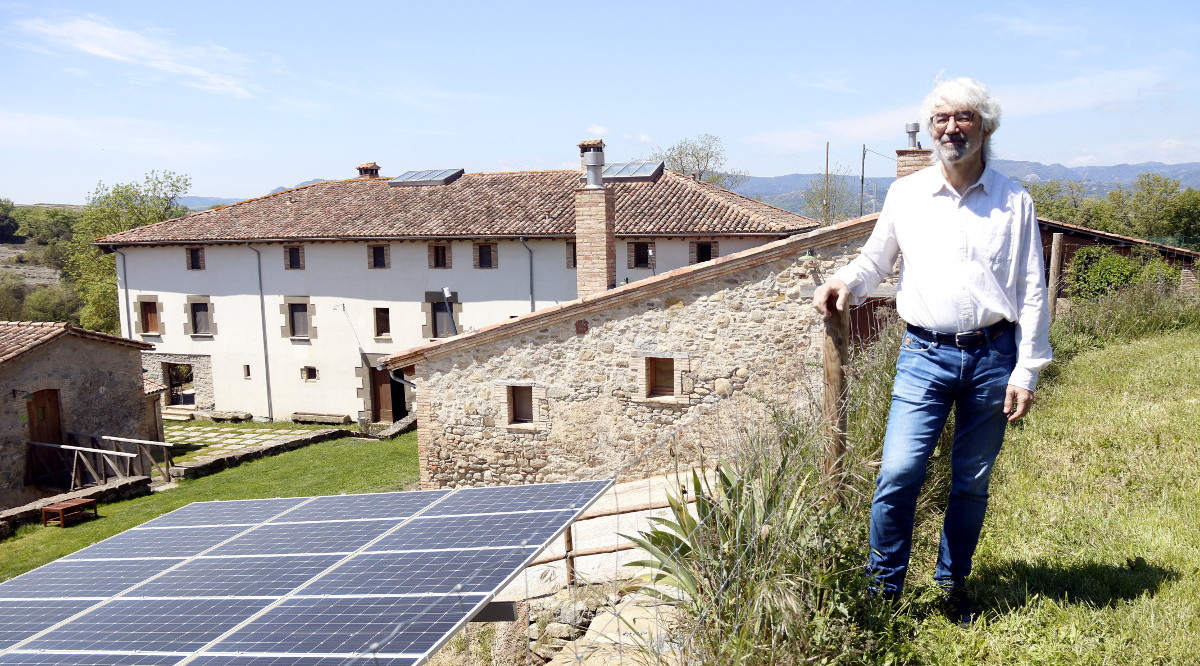 El cofundador de Mas Vinyoles Hub, Ermen Llobet, amb la masia de fons i les plaques el 14 de maig del 2021 a Sant Pere de Torelló. Lourdes Casademont (ACN)